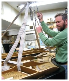 Ken working on a grand piano.